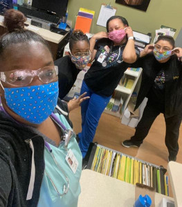 Clincians pose for a picture wearing masks and eye protection.