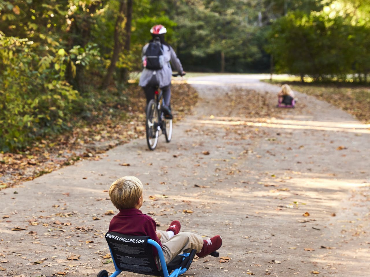 A child rides on a small bike behind his family.