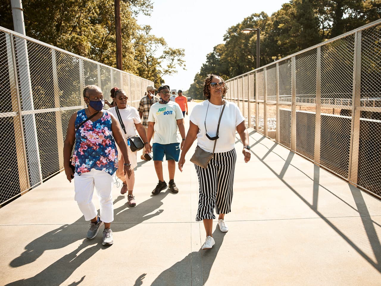 A group of people walk across a bridge.