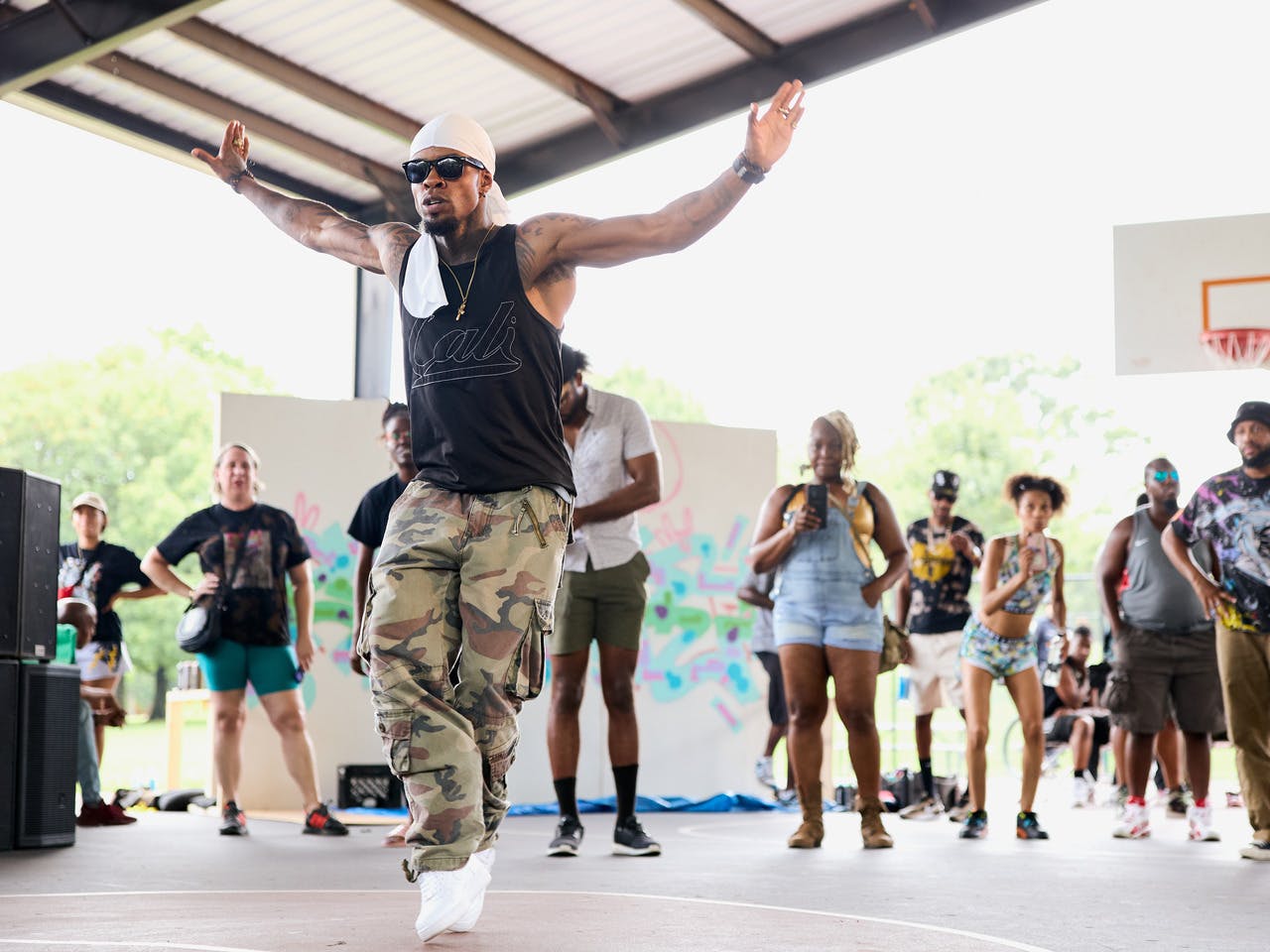 A man dances to hip-hop in front of a crowd.