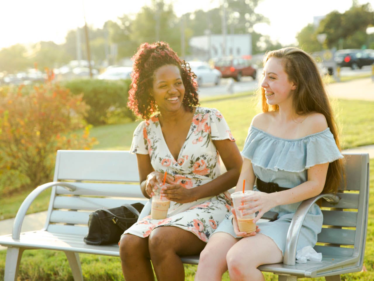 Two women sit on a bench during Art on the Atlanta Beltline performances in Gordon White Park. (Photo Credit: Erin Sintos)