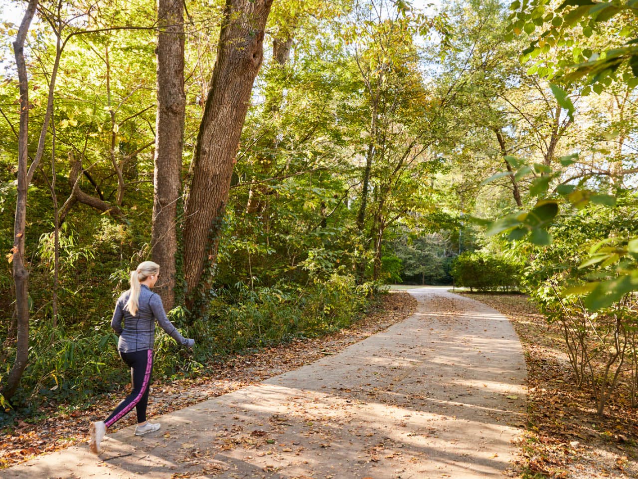 A woman walking through a wooded area on the Northside Trail. Photo by Erin Sintos.