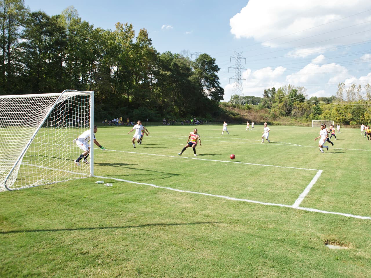 People play soccer on a sunny day.