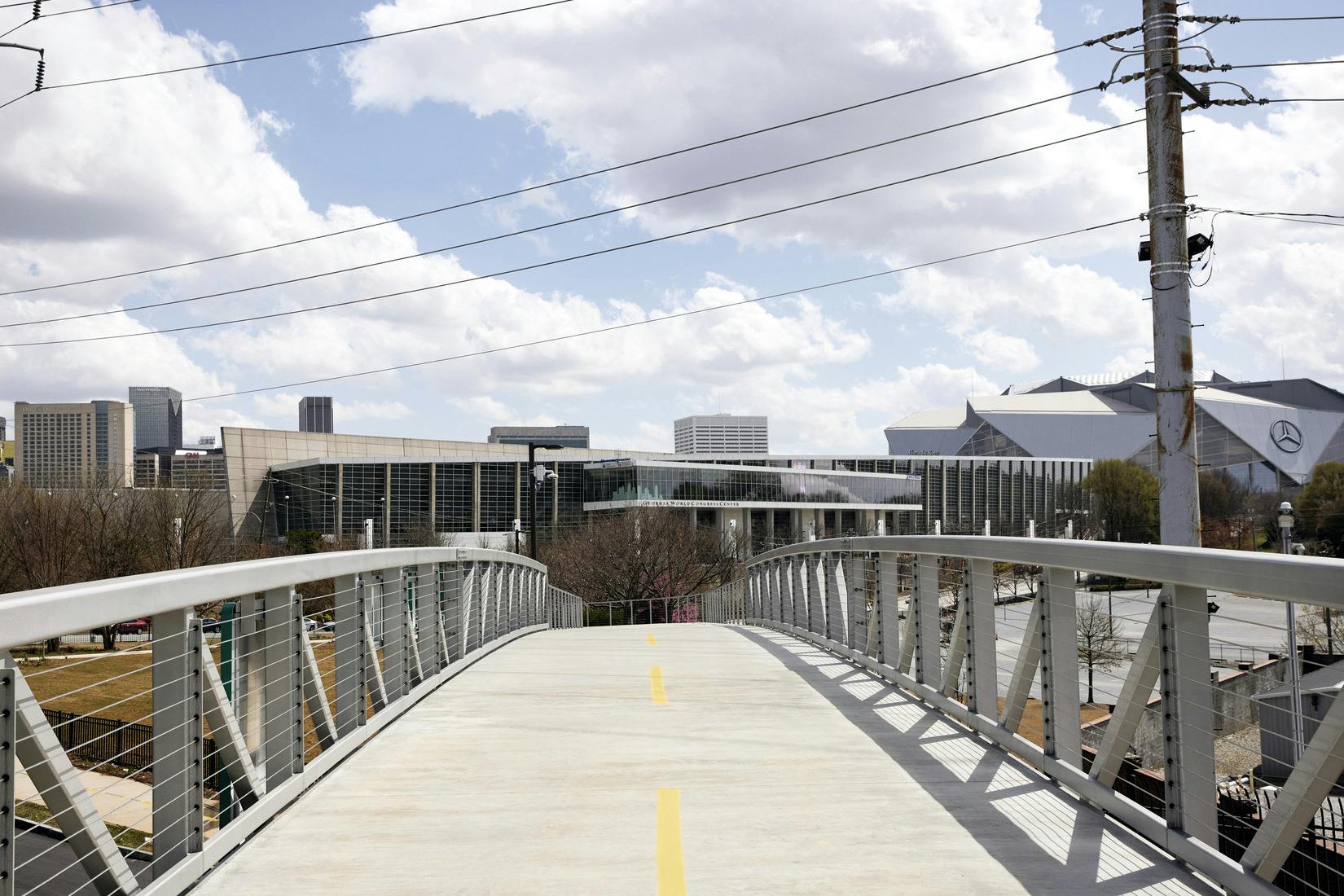 A bridge has a paved pathway over it and leads to the city.
