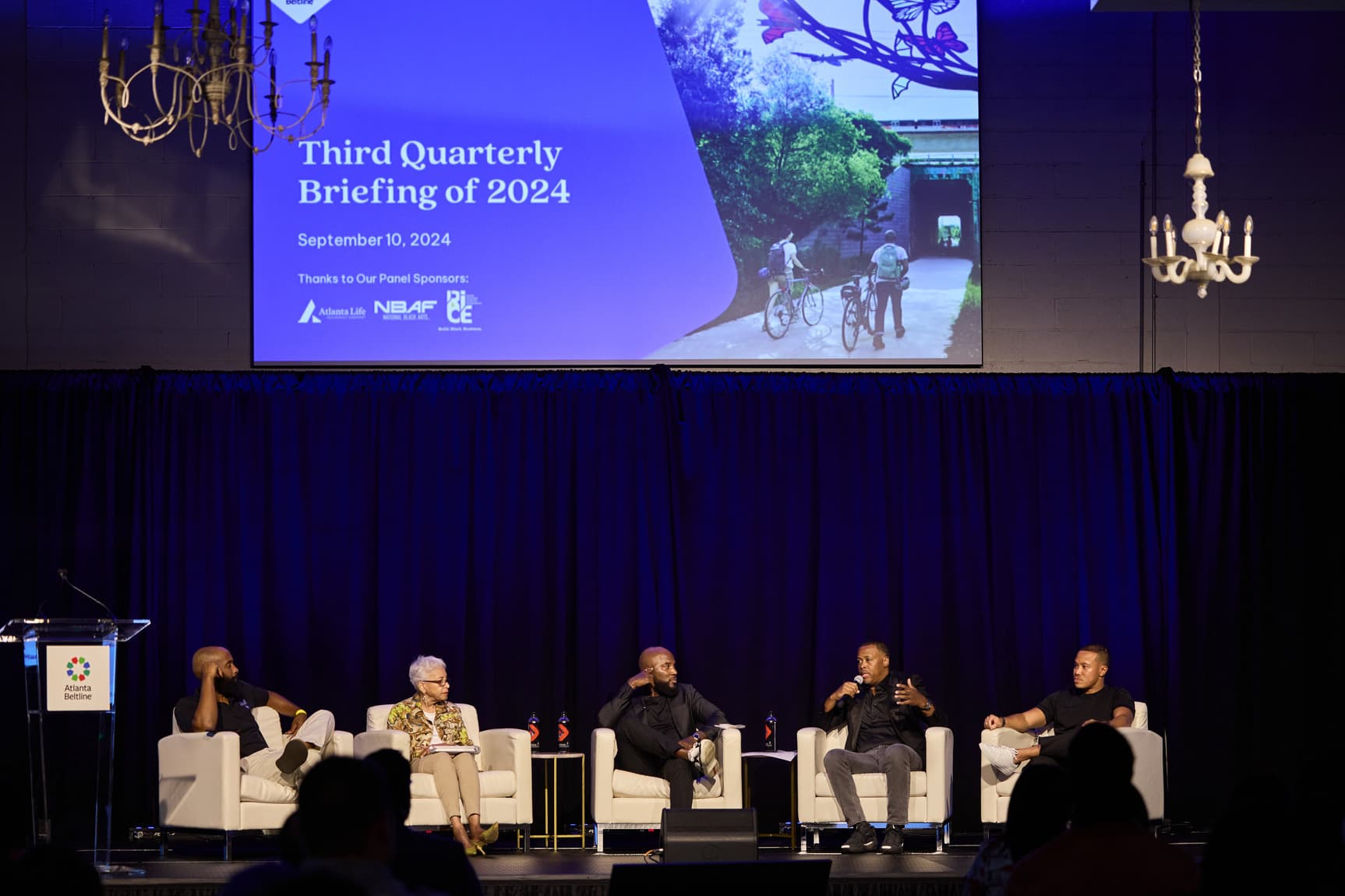 A group of panelists, including Jeezy, sit on a stage talking.