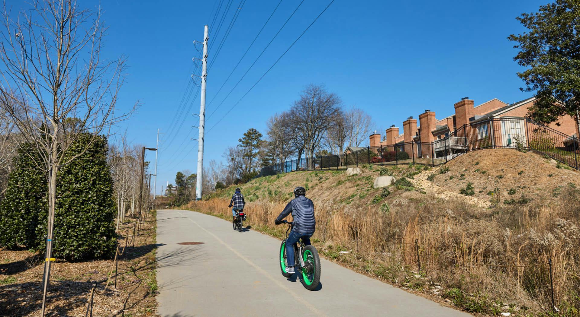 Cyclists ride by condos on the Northeast Trail. (Photo Credit: Erin Sintos)