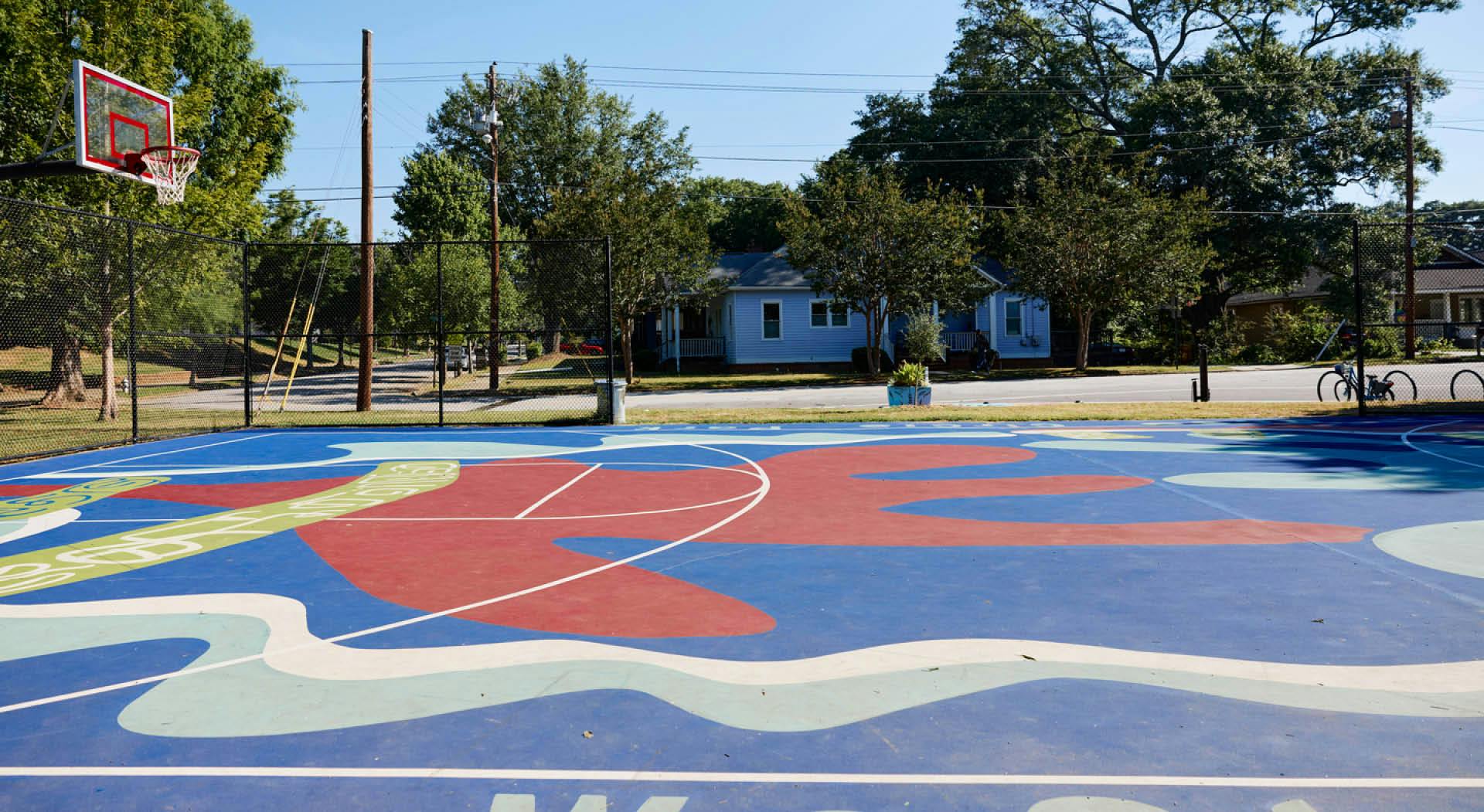 The basketball court is painted in a colorful blue, white, and red mural. (Photo Credit: Erin Sintos)