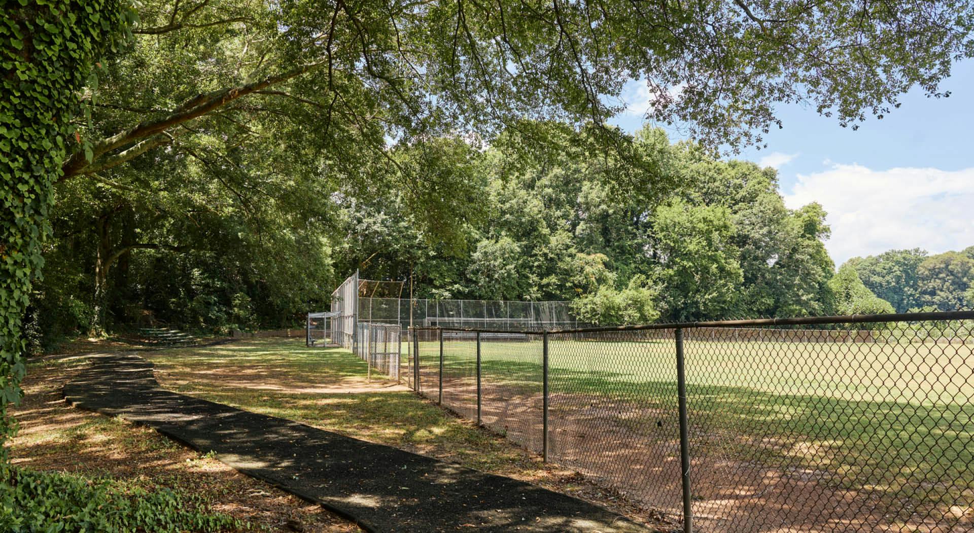 The baseball field in Arthur Langford, Jr. Park with a paved paths and bleachers in the shade. (Photo Credit: Erin Sintos)