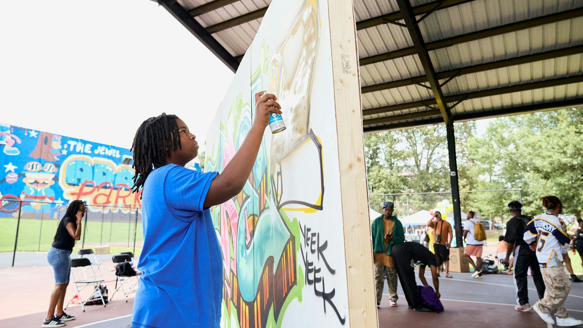 Young girl adds her touch to a live aerosol art canvas curated by Atlanta Style Writers and Cole One at ATL Park Jam
