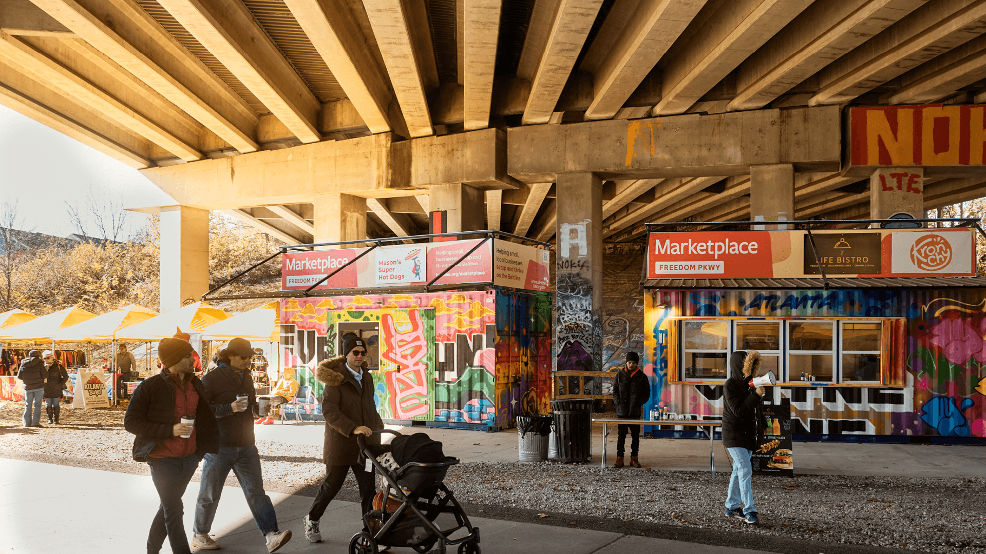 Image of Atlanta Beltline Marketplace at Freedom Parkway. The containers are in the background with people walking on the Eastside Trail in the foreground.