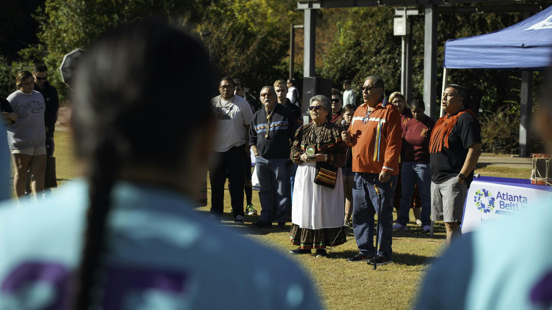 People look on as two members of the Muscogee Nation lead an opening ceremony.
