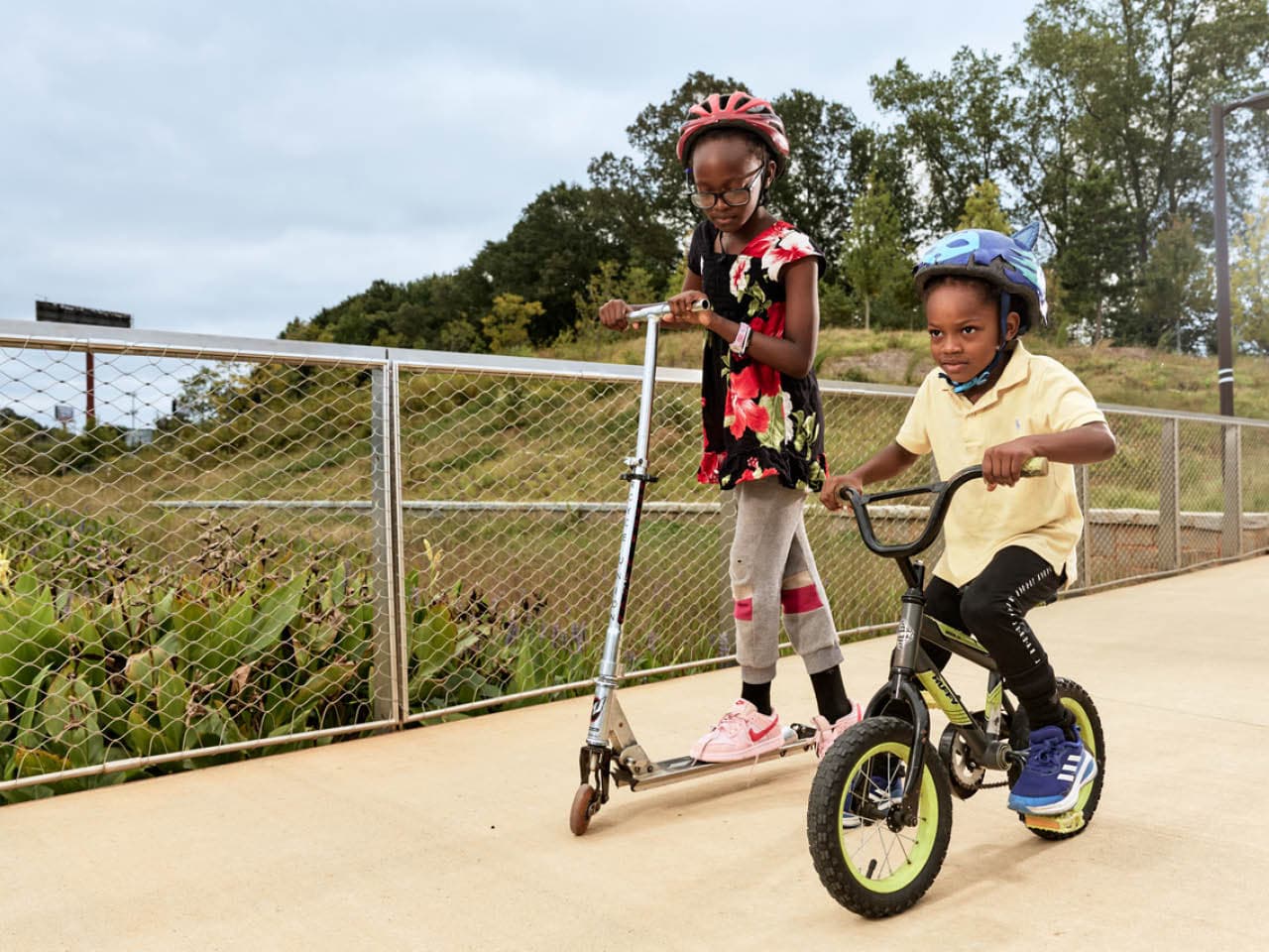 Two kids ride a scooter and bike on the Southside Trail. Photo by Erin Sintos.
