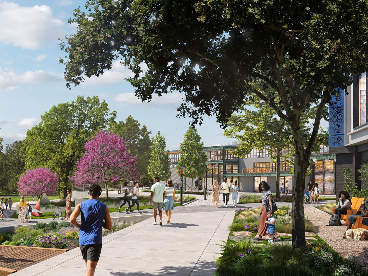 People walking and jogging on a tree-lined path in a modern mixed-use area with greenery and a building in the background.