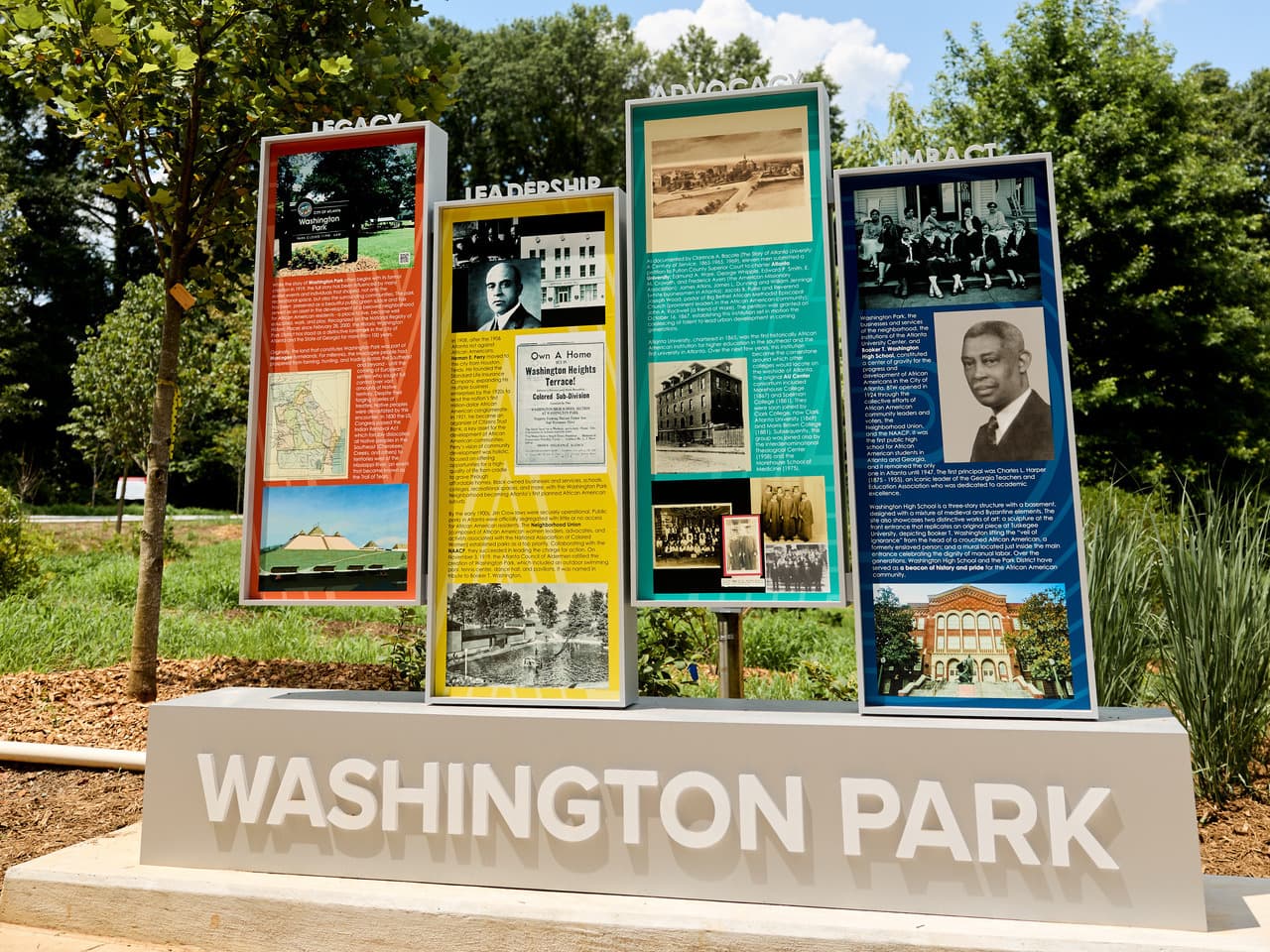 Historical display at Washington Park featuring informational panels on legacy, leadership, advocacy, and impact, with photos and text, surrounded by trees.