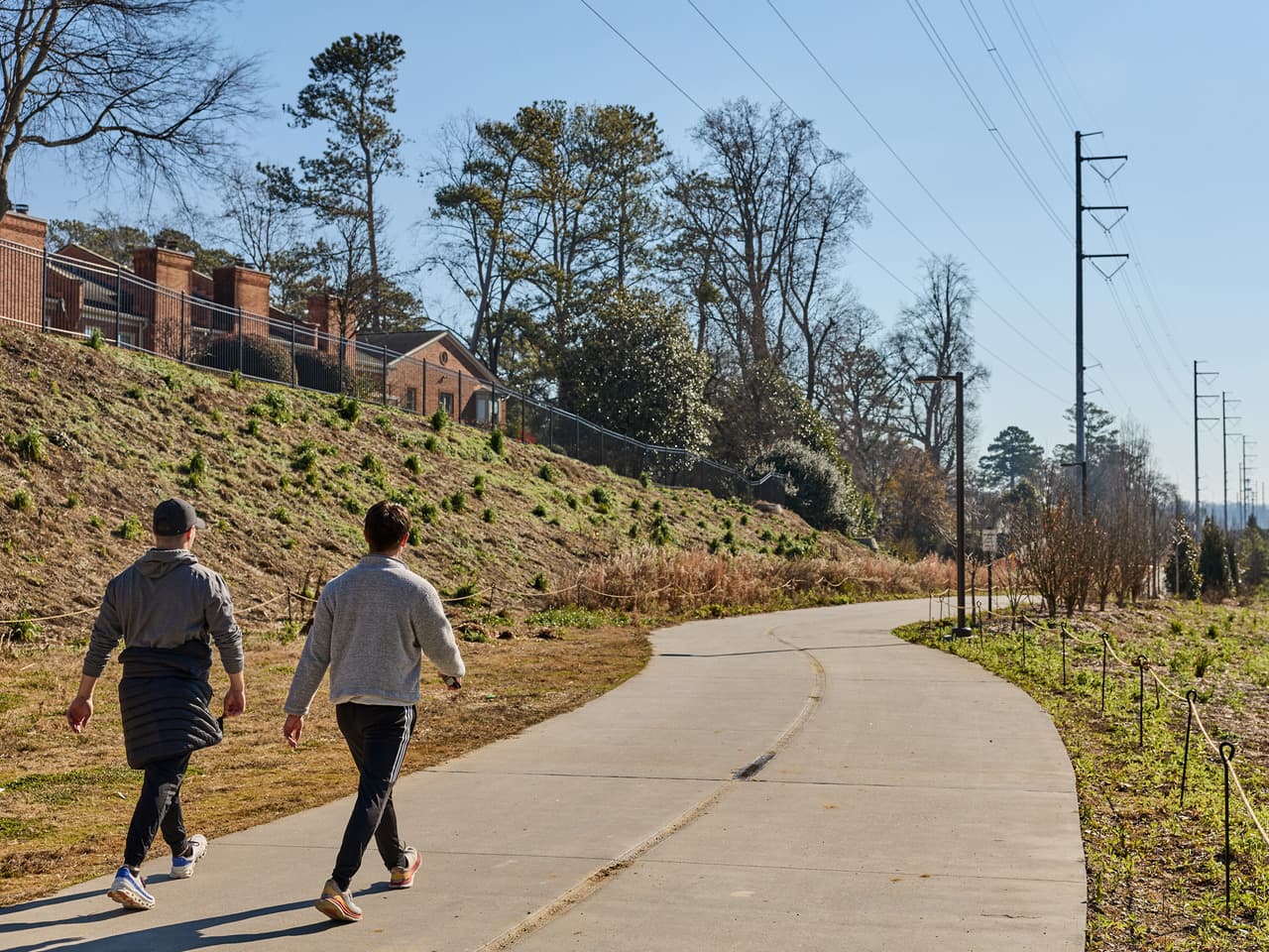 Two men walk along a pathway.