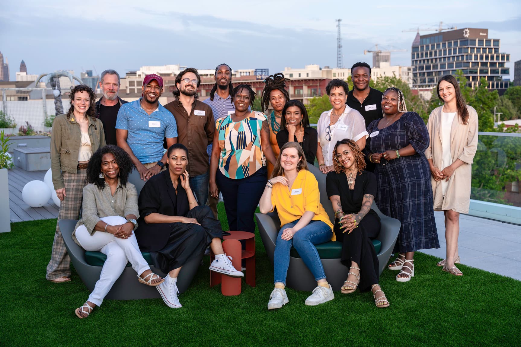 A group of artists pose together on a rooftop.