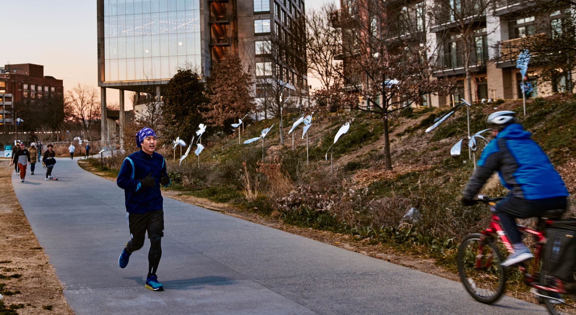 At dusk, a runner passes by oak leaf sculptures made of stainless steel. (Photo Credit: Erin Sintos)