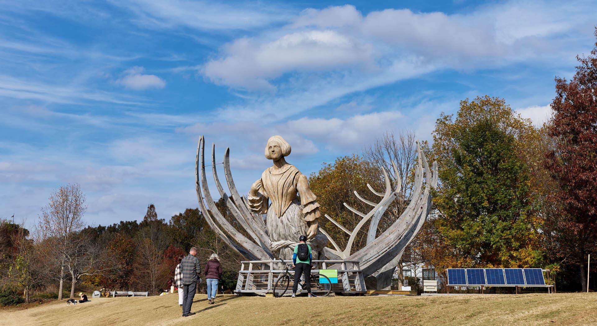 Large sculpture titled "Wake" by Mel Chin depicting the structural ribs of the U.S.S. Nightingale, rising from the ground to frame a 21-foot-tall figurative sculpture. (Photo Credit: Erin Sintos)