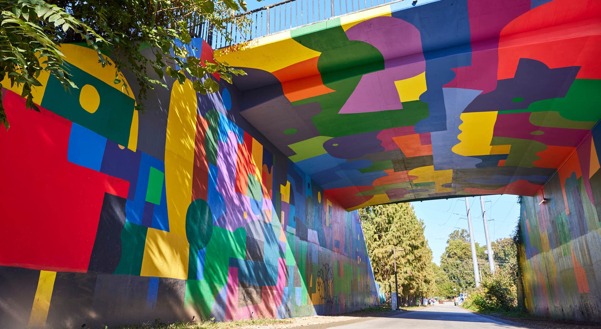 A mural of bright patchwork shapes by HENSE cover the inside of the Virginia Avenue tunnel on the Eastside Trail. (Photo Credit: Erin Sintos)