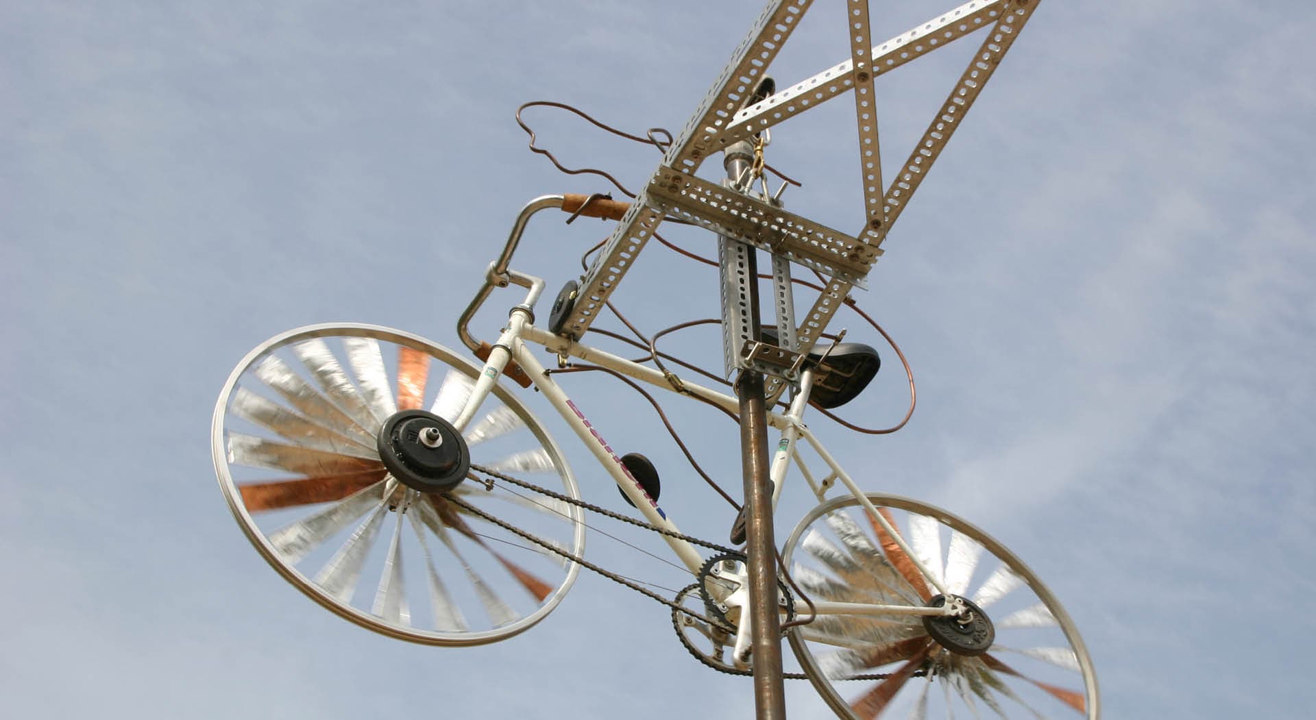 Sculpture made out of bicycle parts on a pole.