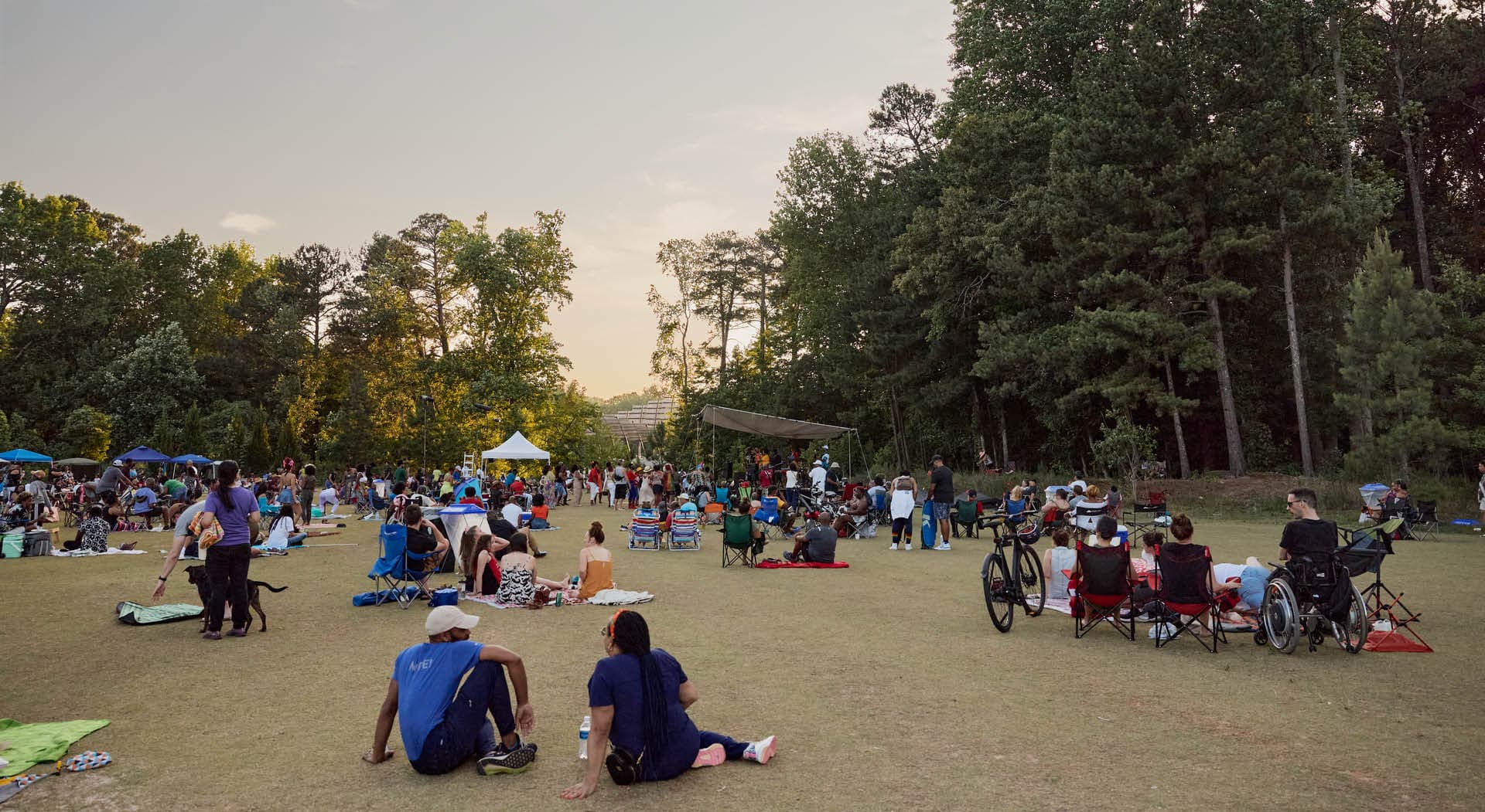 The sun sets over the audience at Beltline After Dark art performances in Shirley Clarke Franklin Park. (Photo Credit: Erin Sintos)
