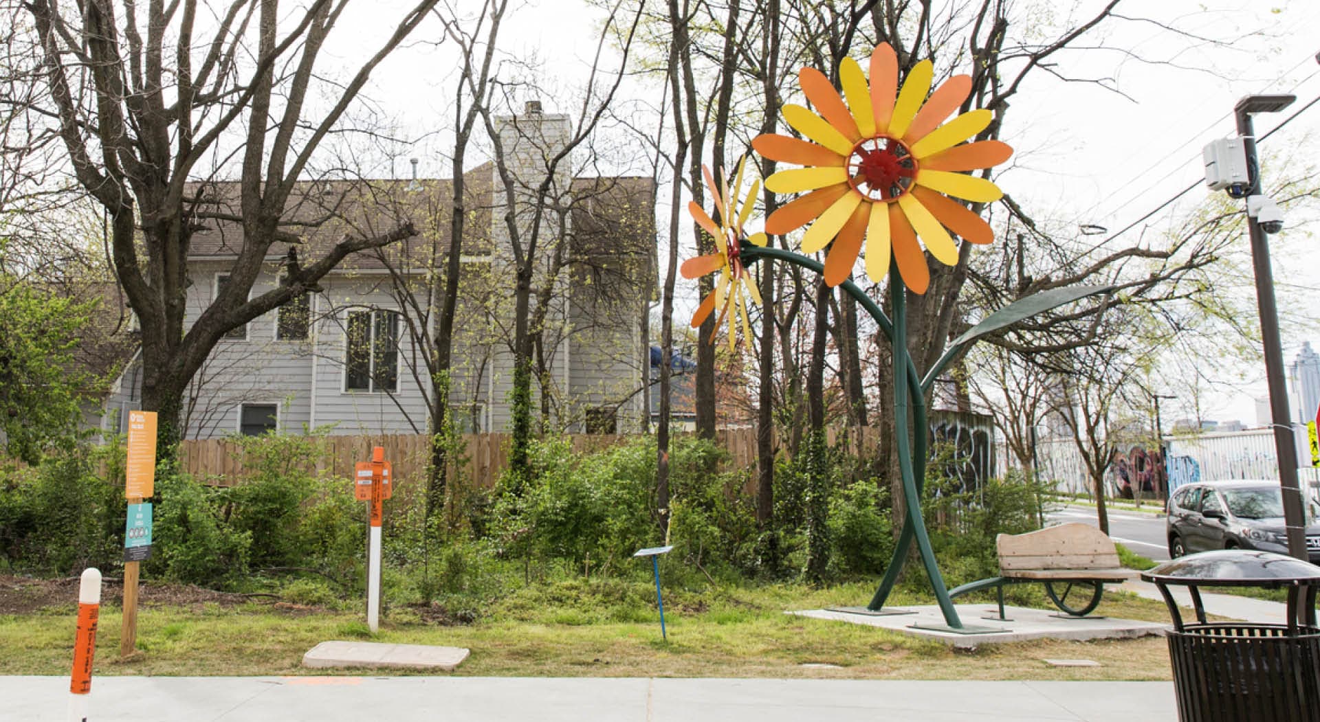 A large orange, yellow, and red metal flower sculpture titled "Blossom" by Richard Herzog. (Photo Credit: Erin Sintos)