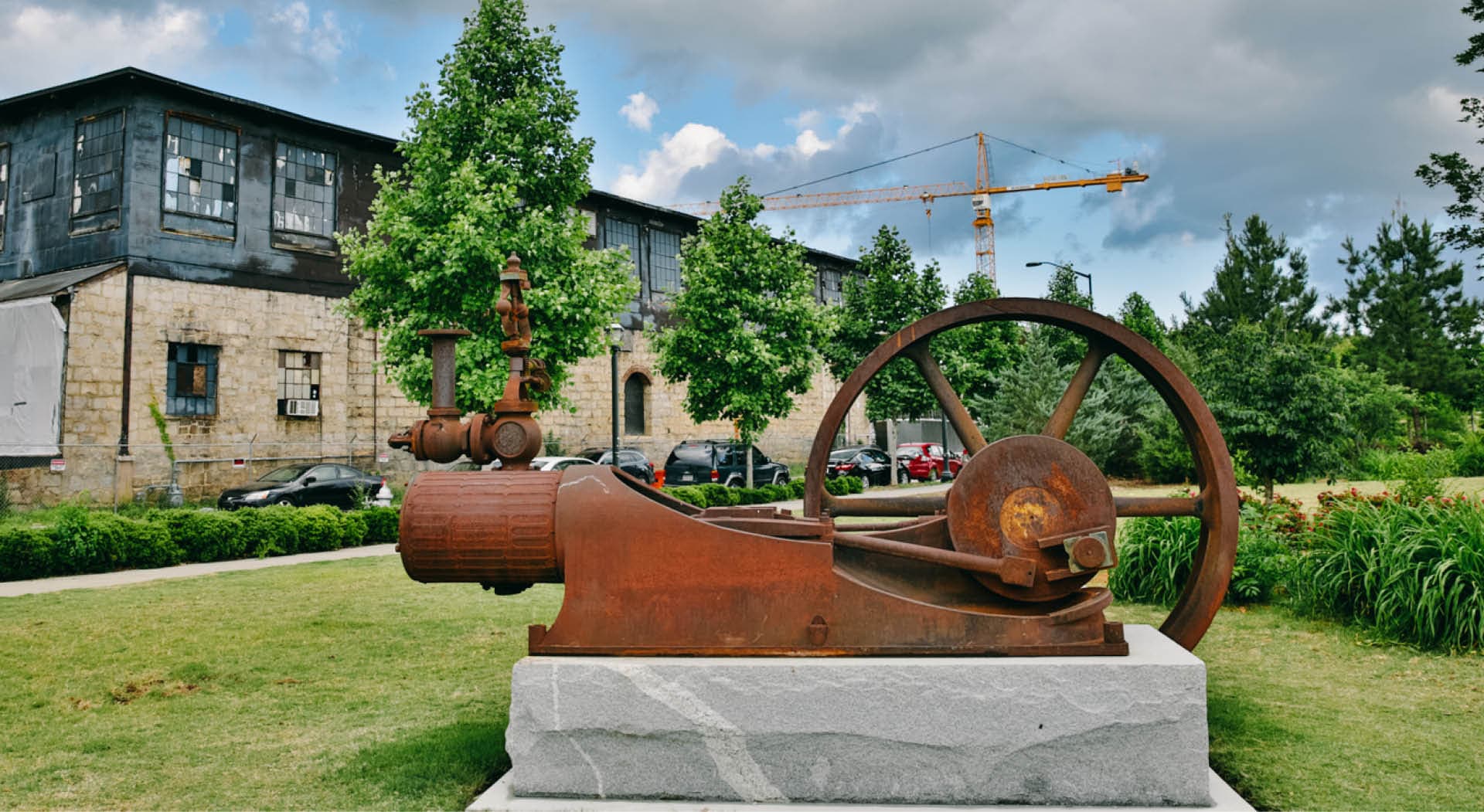 The historic steam engine from a mill stands on a stone pedestal in the park. (Photo Credit: Erin Sintos)