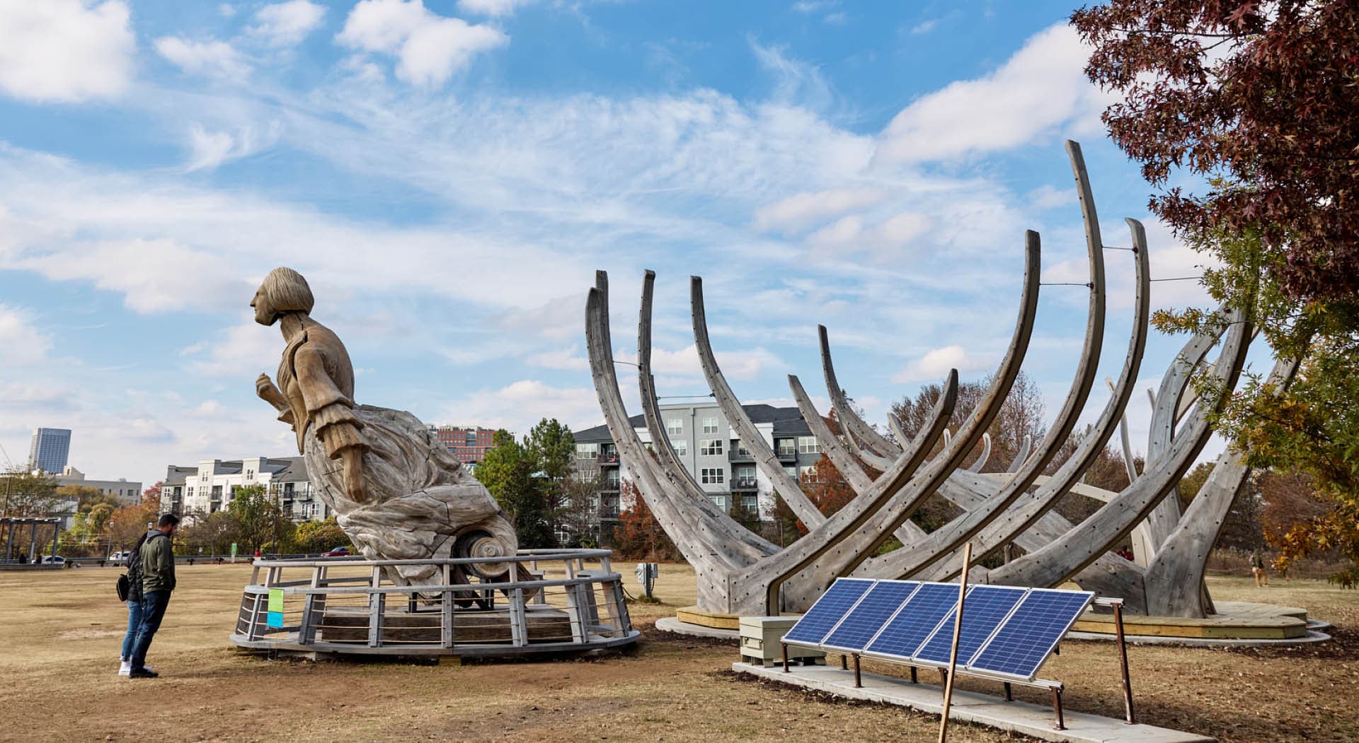 Large sculpture titled "Wake" by Mel Chin depicting the structural ribs of the U.S.S. Nightingale, rising from the ground to frame a 21-foot-tall figurative sculpture. (Photo Credit: Erin Sintos)