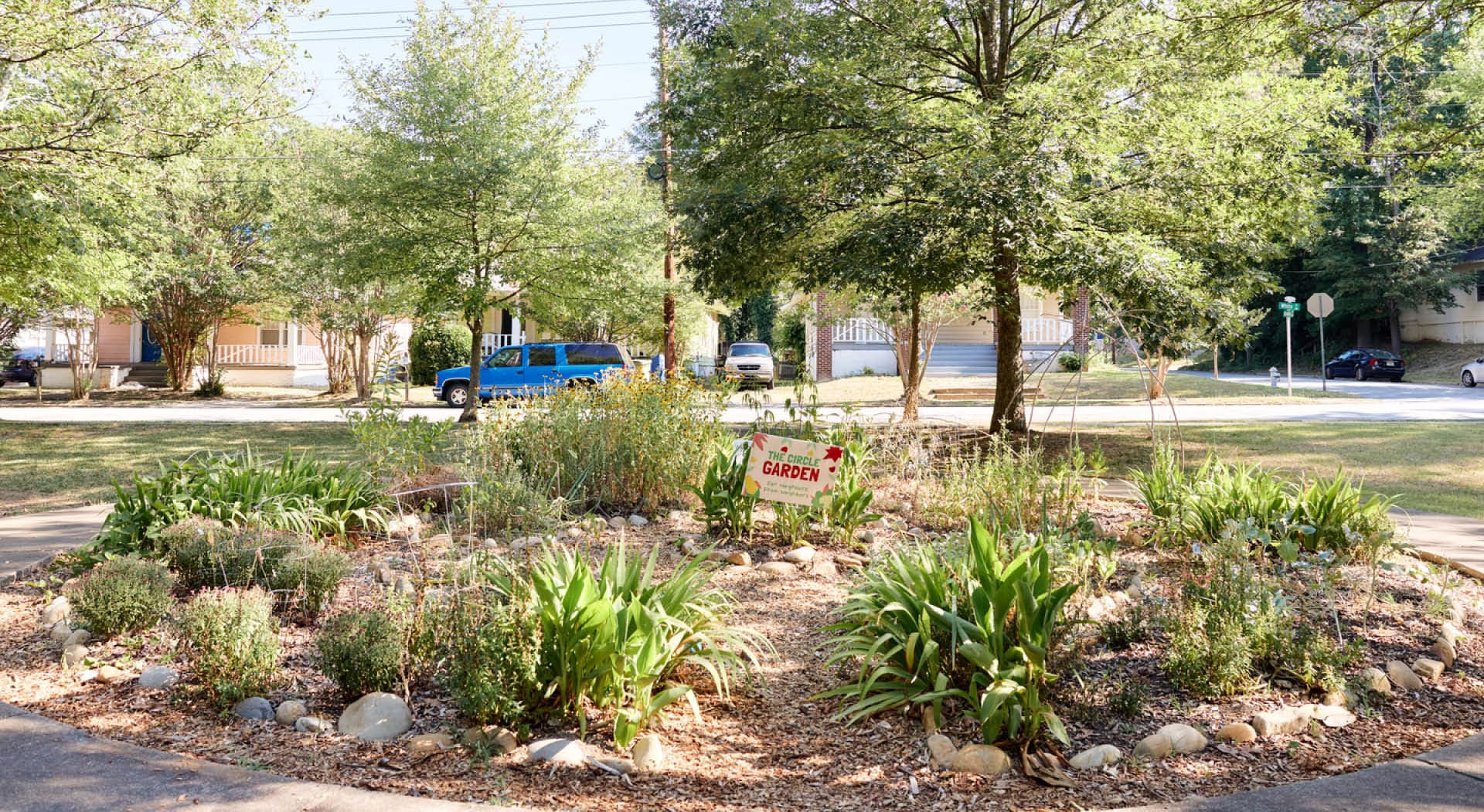 A community garden in Rose Circle Park with a sign that says "for neighbors, from neighbors." (Photo Credit: Erin Sintos)