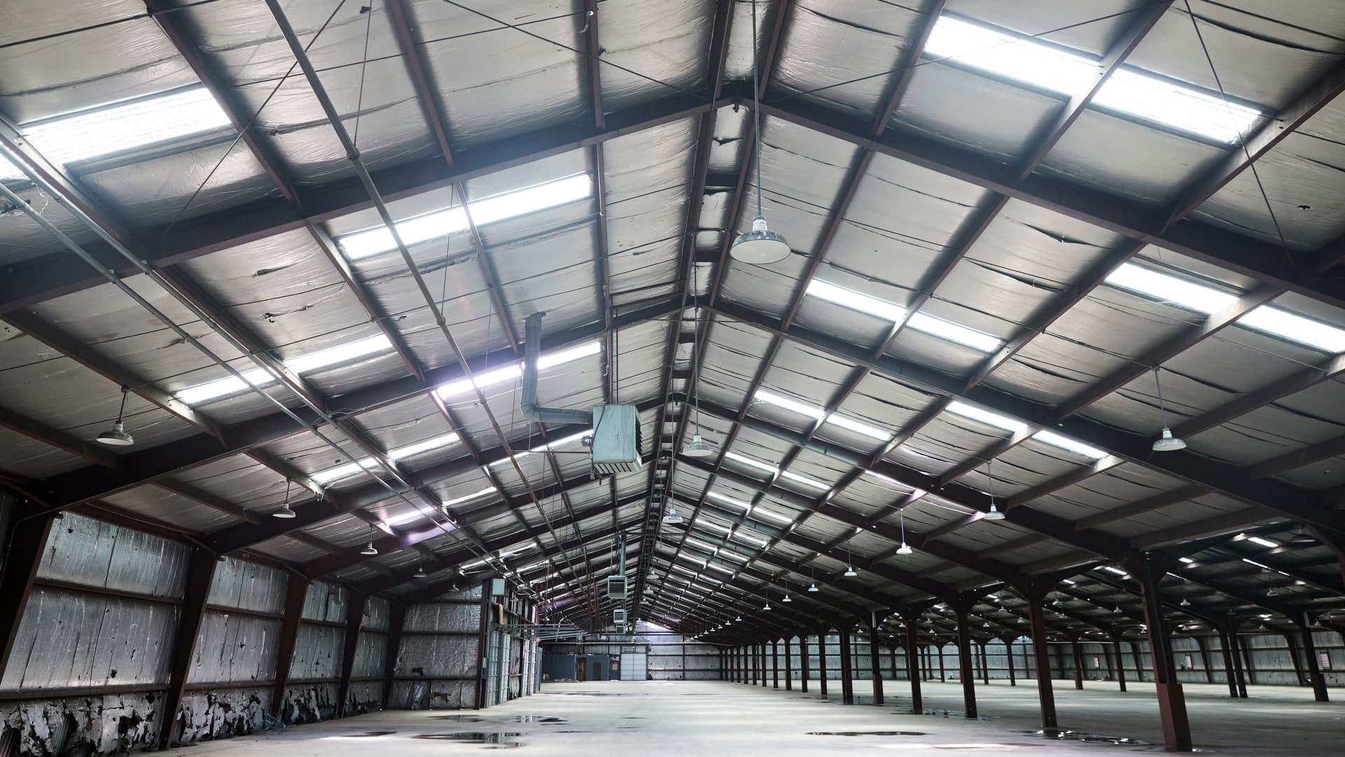 The inside of an abandoned warehouse is lit up.