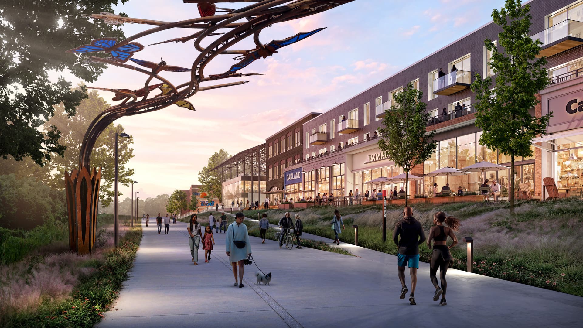 People walk and relax along a scenic, tree-lined path near a shopping area with sculptures, shops, and outdoor seating at dusk.