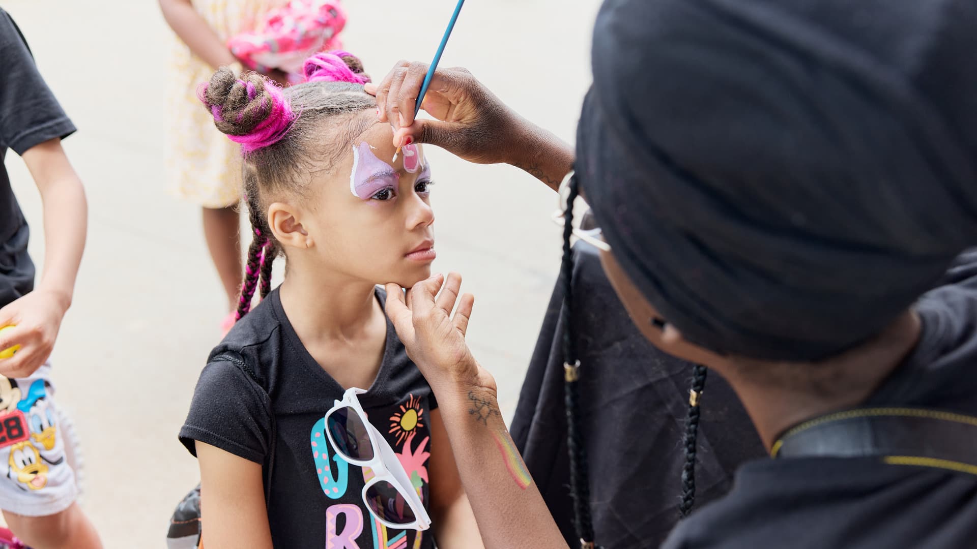 A girl gets her face painted.