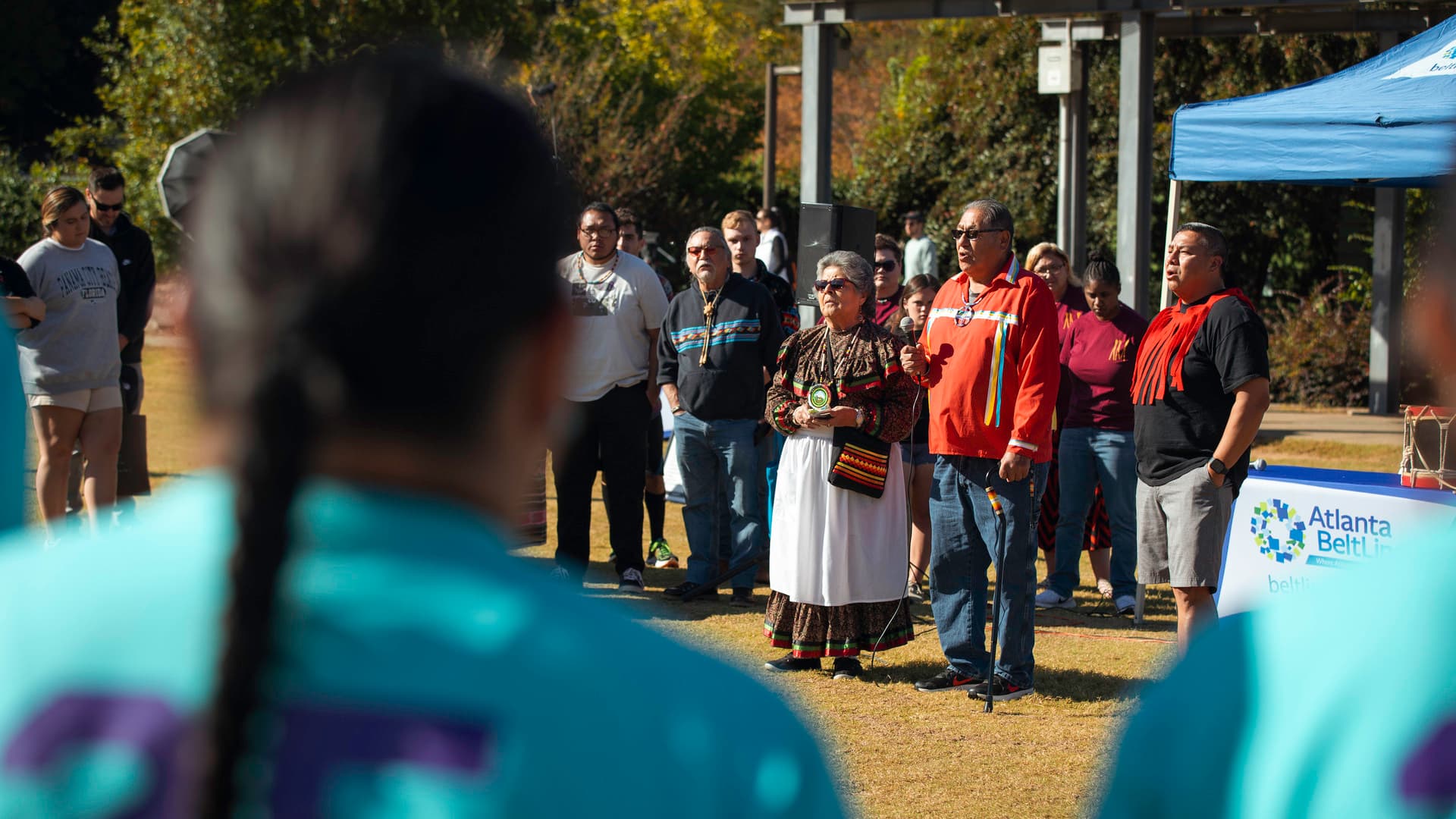 People look on as two members of the Muscogee Nation lead an opening ceremony.