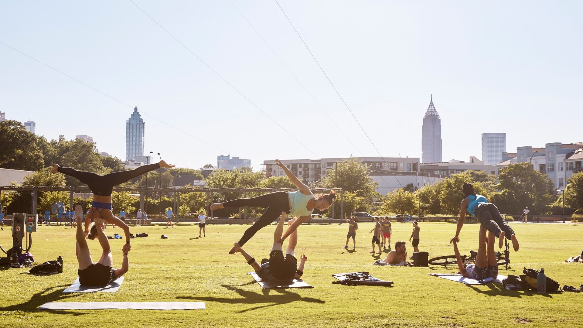 People participating in a yoga session amidst nature at a park.